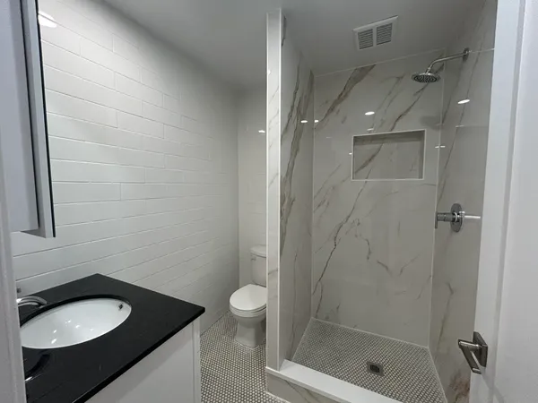 a bathroom with a sink a toilet and shower