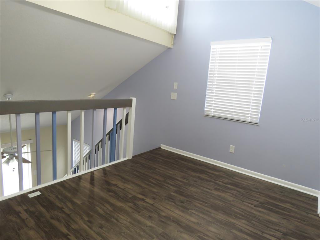 418 Narvaezi Street Venice, FL 34285 - Photo 12 of 67 a view of an empty room with wooden floor and a window