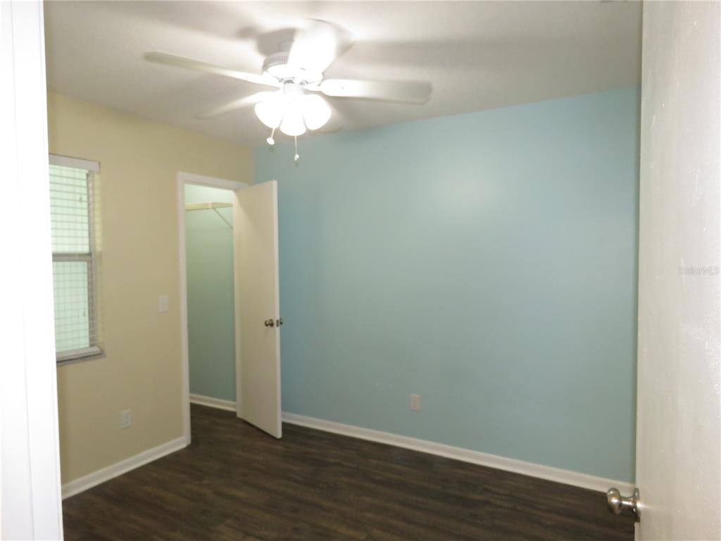 418 Narvaezi Street Venice, FL 34285 - Photo 18 of 67 an empty room with wooden floor and fan