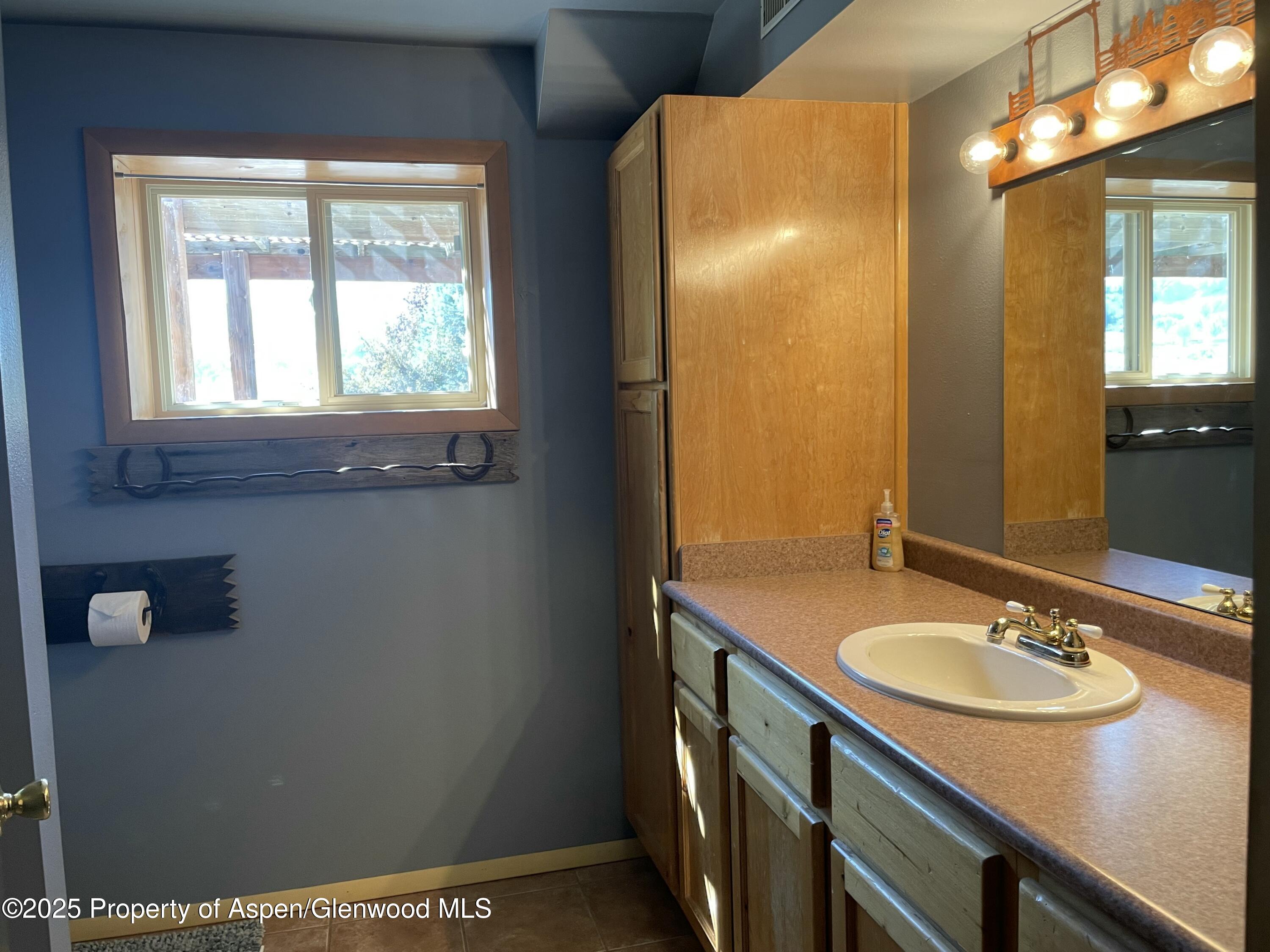 8700 County Road 300 Parachute, CO 81635 - Photo 112 of 201 a bathroom with a sink and mirror