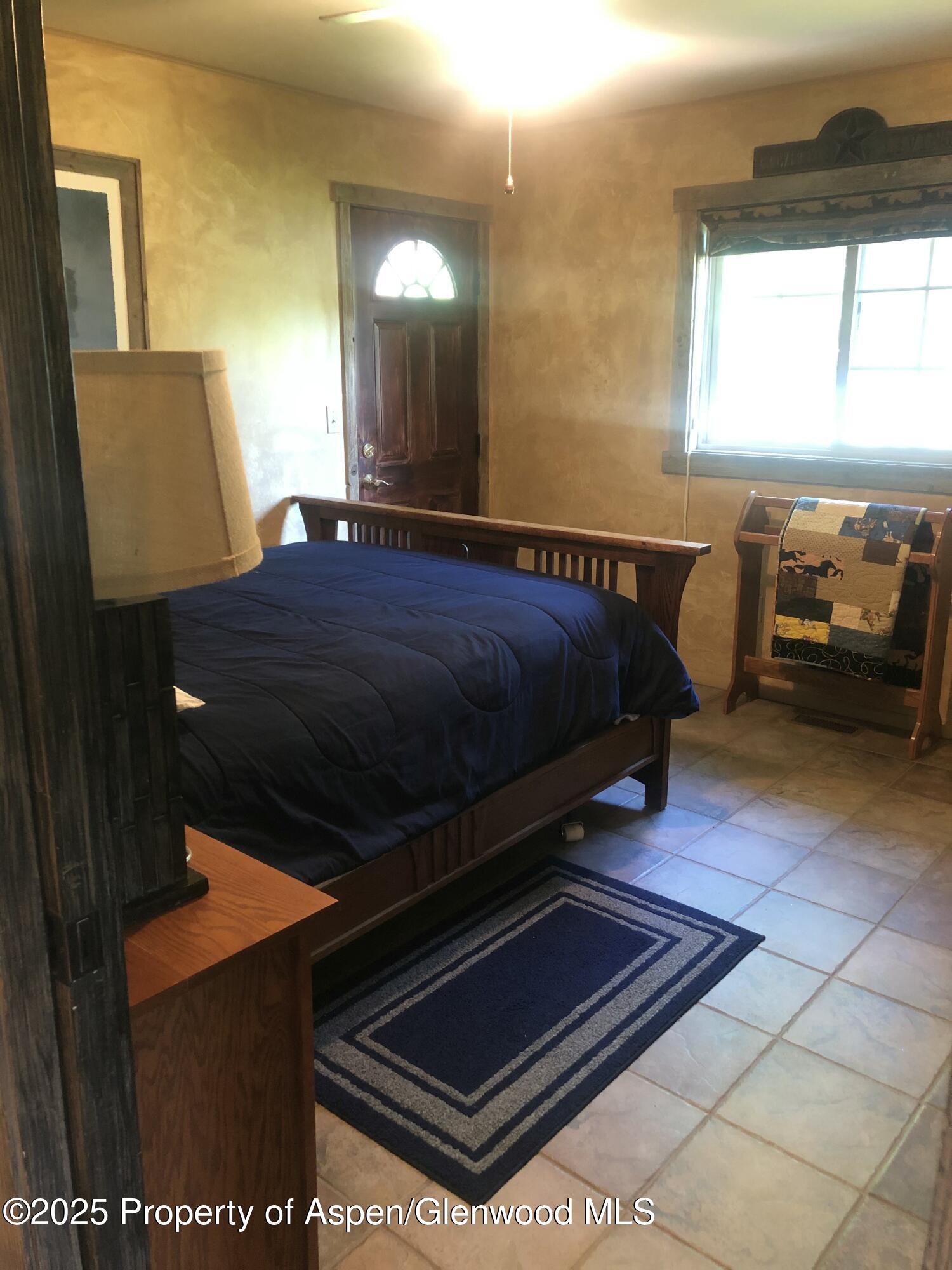 8700 County Road 300 Parachute, CO 81635 - Photo 120 of 201 a bed sitting in a bedroom next to a window