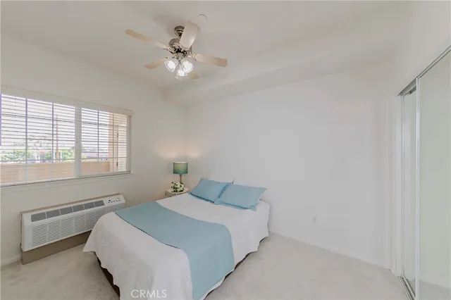 a bedroom with a bed and a ceiling fan