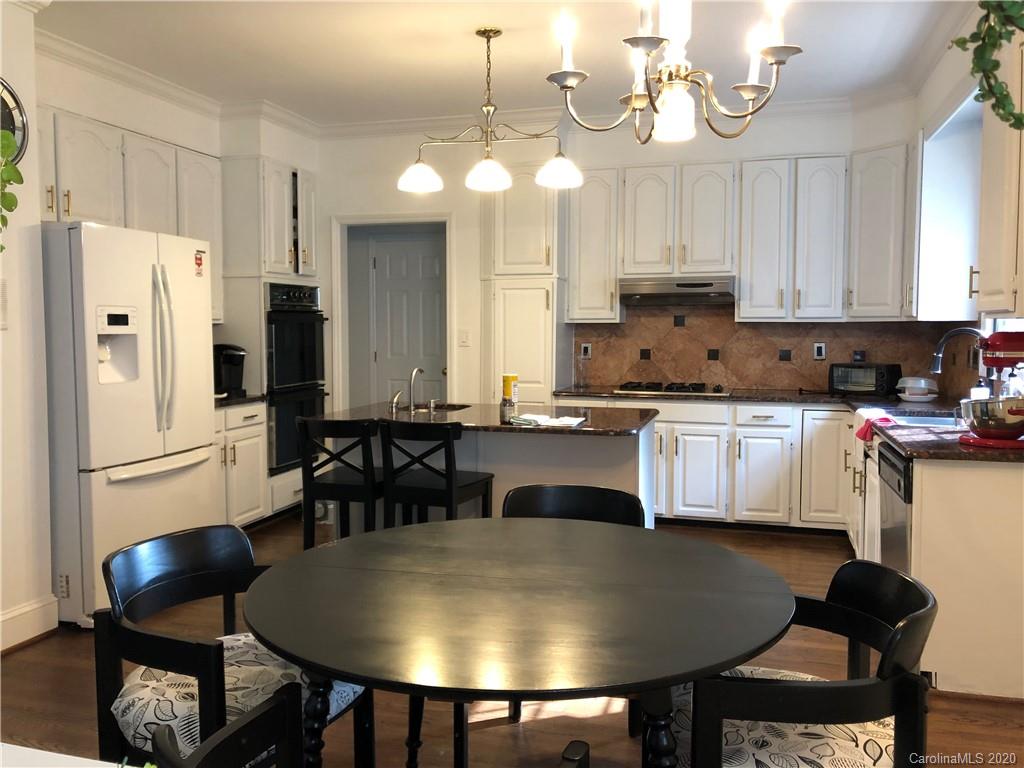 426 St Michaels Way, Unit 15 Fort Mill, SC 29708 - Photo 23 of 25 a kitchen with stainless steel appliances granite countertop a stove a refrigerator a kitchen island a table and chairs in it