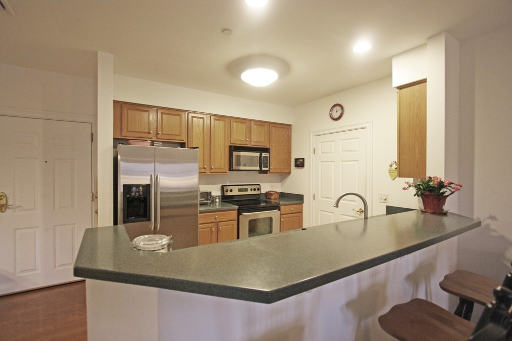 190 Chickering, Unit 210D North Andover, MA 01845 - Photo 3 of 16 a kitchen with stainless steel appliances granite countertop a sink a stove and refrigerator