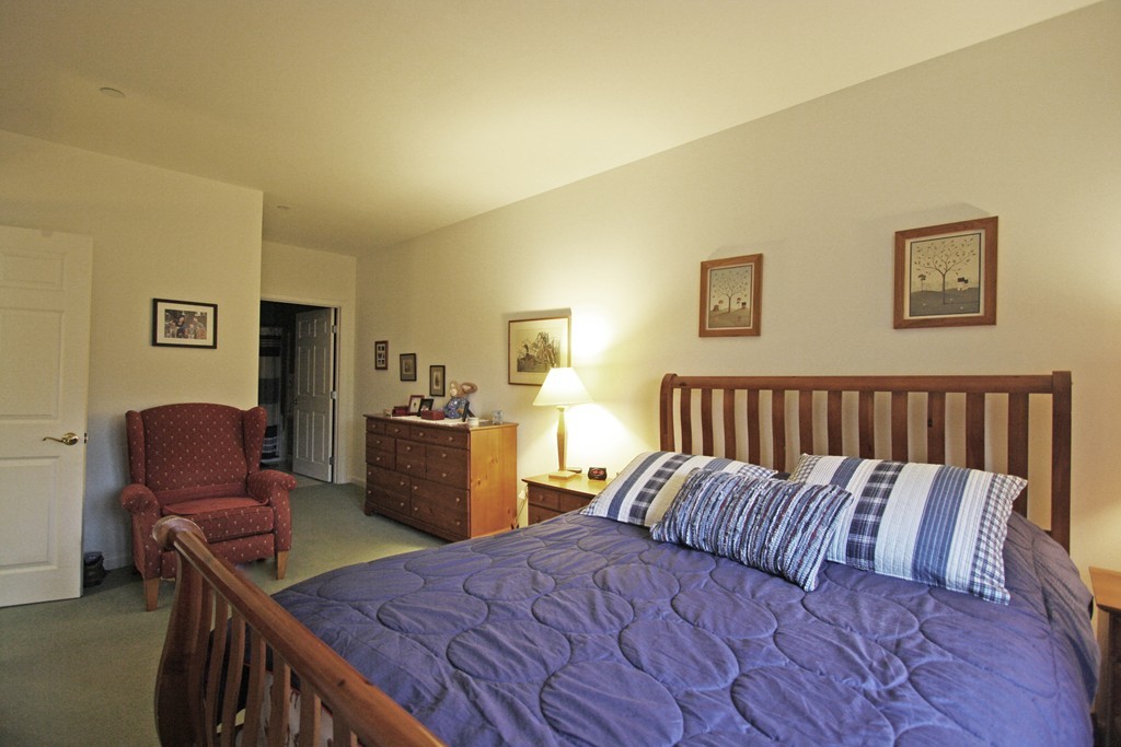190 Chickering, Unit 210D North Andover, MA 01845 - Photo 7 of 16 a bed room with a bed and chair