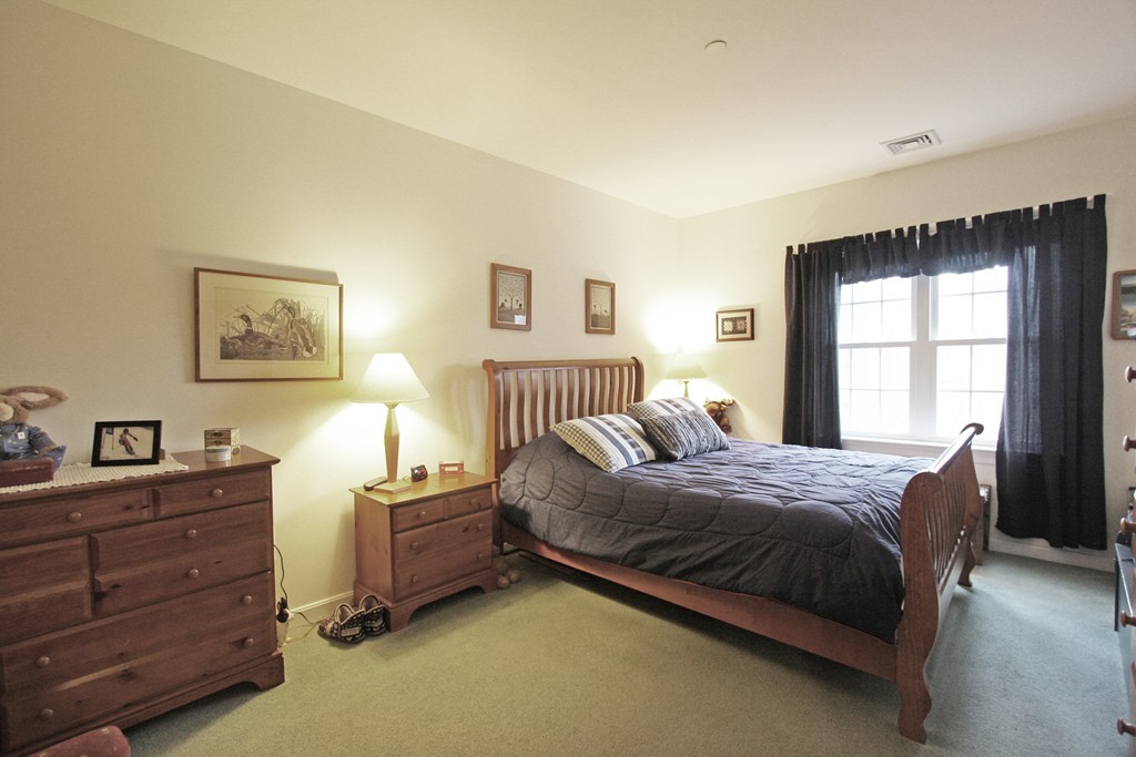 190 Chickering, Unit 210D North Andover, MA 01845 - Photo 8 of 16 a bedroom with a bed and a window