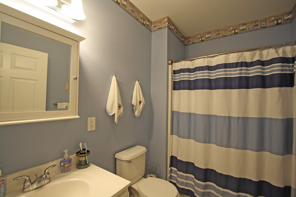 190 Chickering, Unit 210D North Andover, MA 01845 - Photo 9 of 16 a bathroom with a sink a toilet and shower curtain