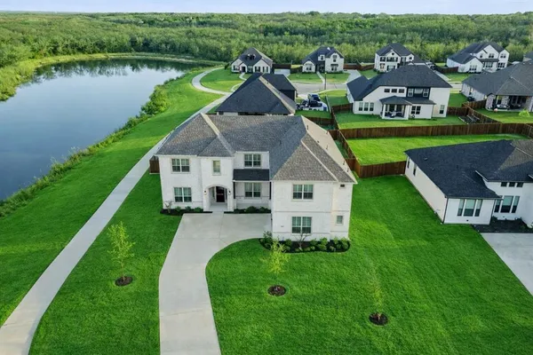 an aerial view of a house with swimming pool tennis courts and lake view