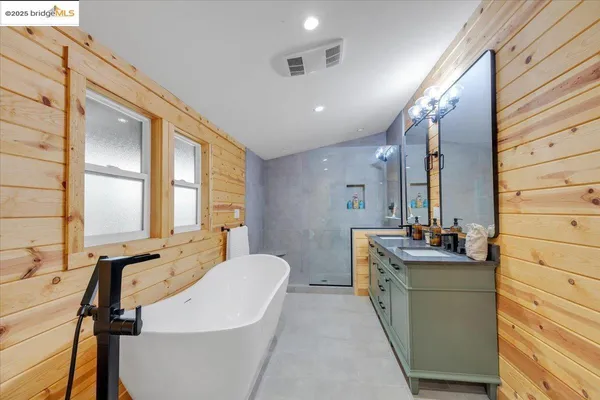 a bathroom with a double vanity sink a mirror and a bathtub