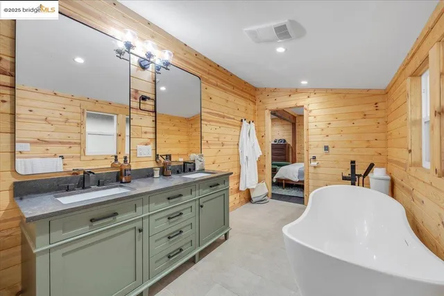a bathroom with a double vanity sink a mirror and a bathtub