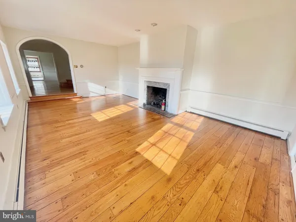 a view of empty room with wooden floor and fireplace