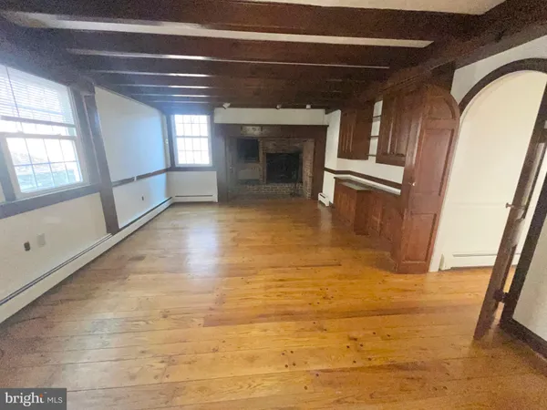 a view of empty room with wooden floor and fireplace