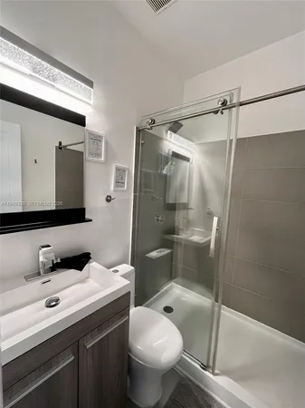 a bathroom with a granite countertop sink toilet and shower