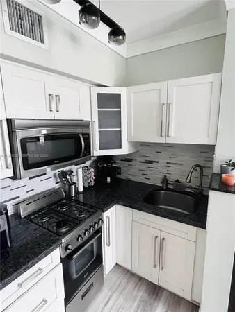 a kitchen with stainless steel appliances a stove a sink and a microwave