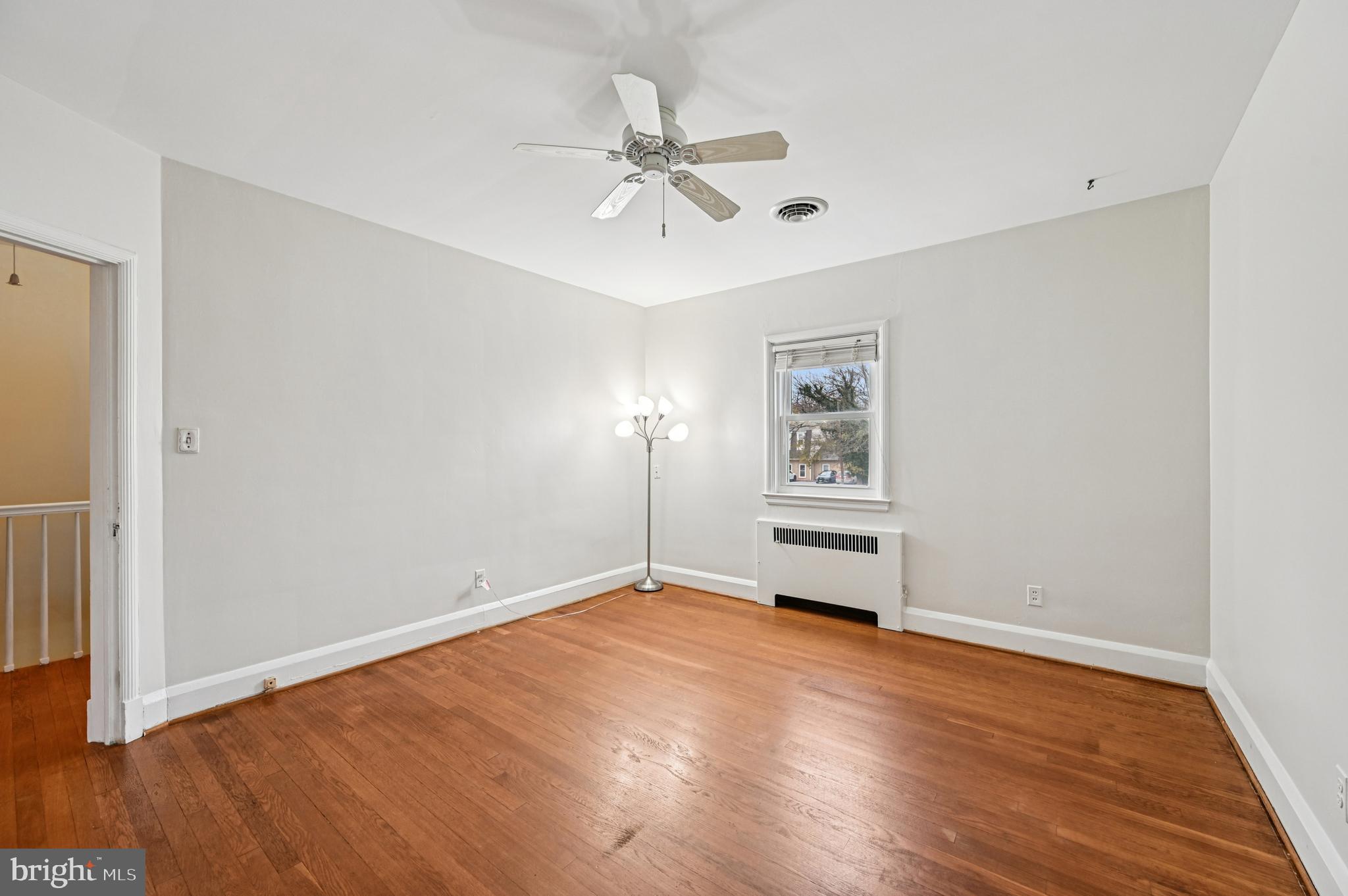 19 Somerset Road Baltimore, MD 21228 - Photo 17 of 39 an empty room with wooden floor chandelier fan and windows