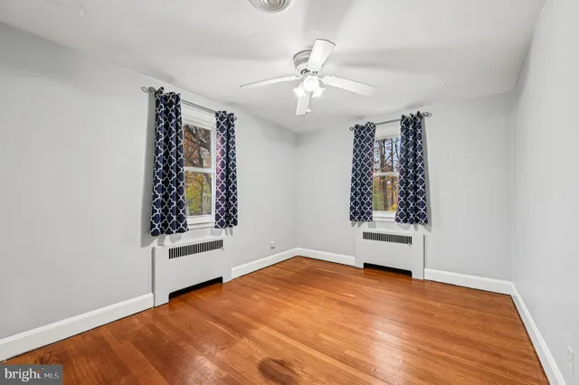 a view of an empty room with wooden floor