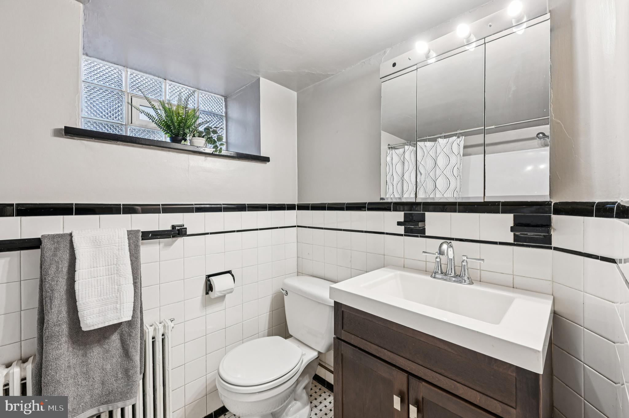 19 Somerset Road Baltimore, MD 21228 - Photo 31 of 39 a bathroom with a sink a toilet and mirror