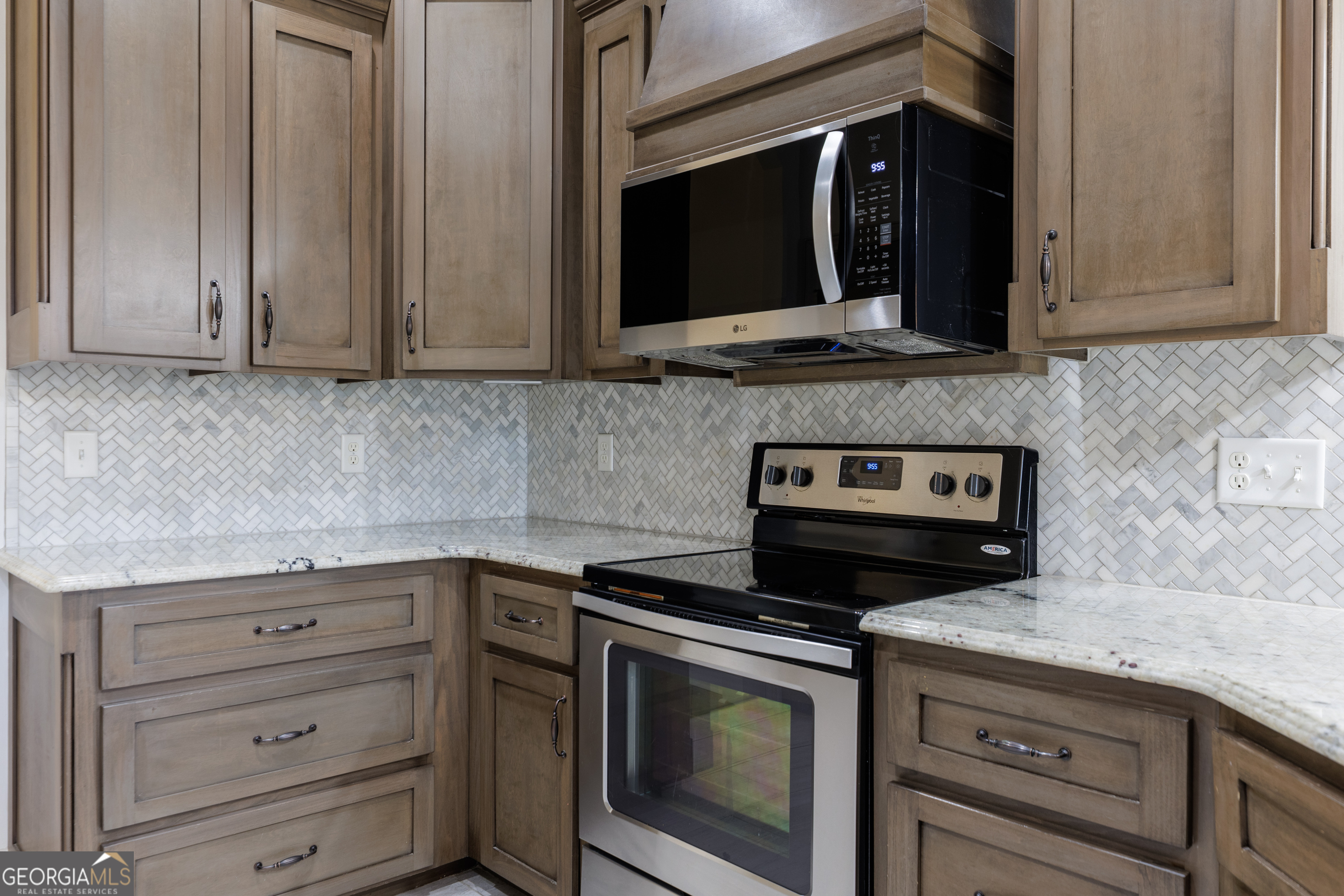 5109 Village Way Hahira, GA 31632 - Photo 13 of 42 a kitchen with granite countertop cabinets stove and microwave