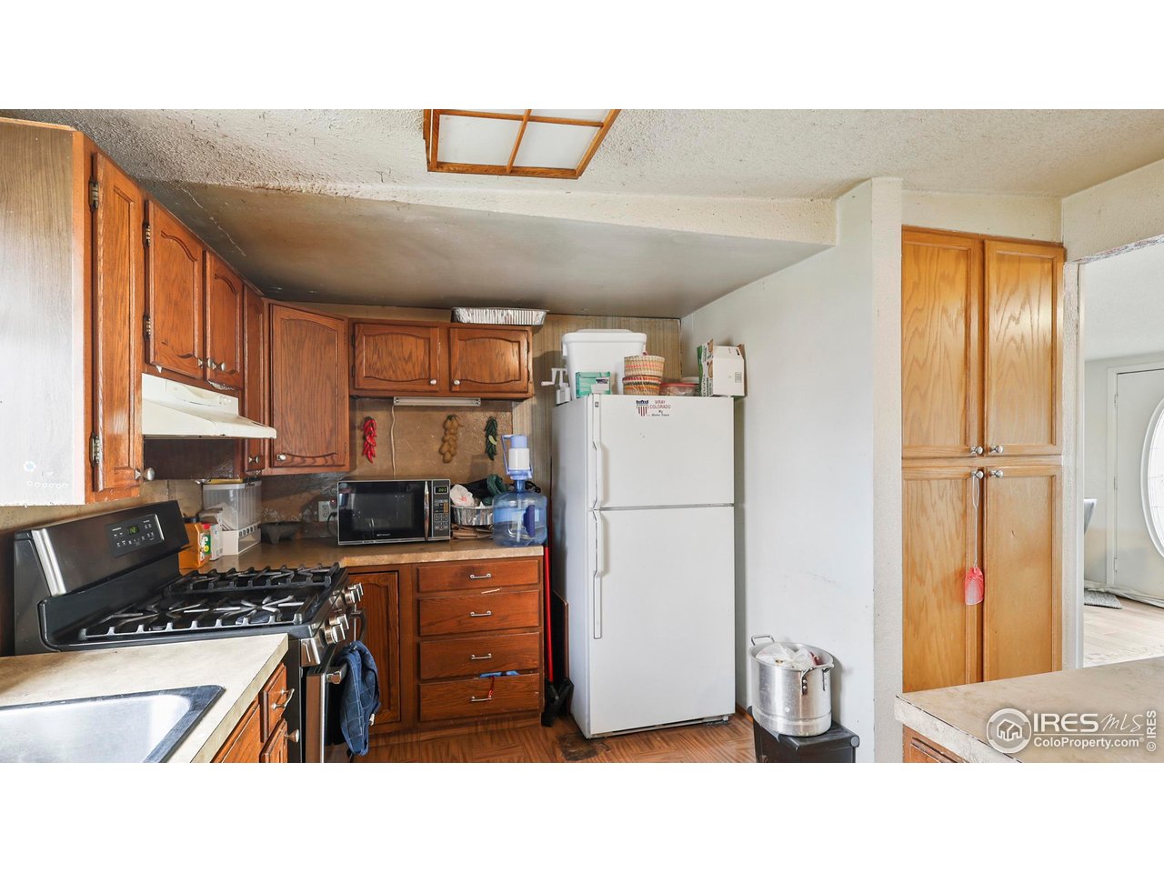 15985 Echo Road Fort Morgan, CO 80701 - Photo 6 of 22 a kitchen with a refrigerator a stove a sink dishwasher and cabinets with wooden floor