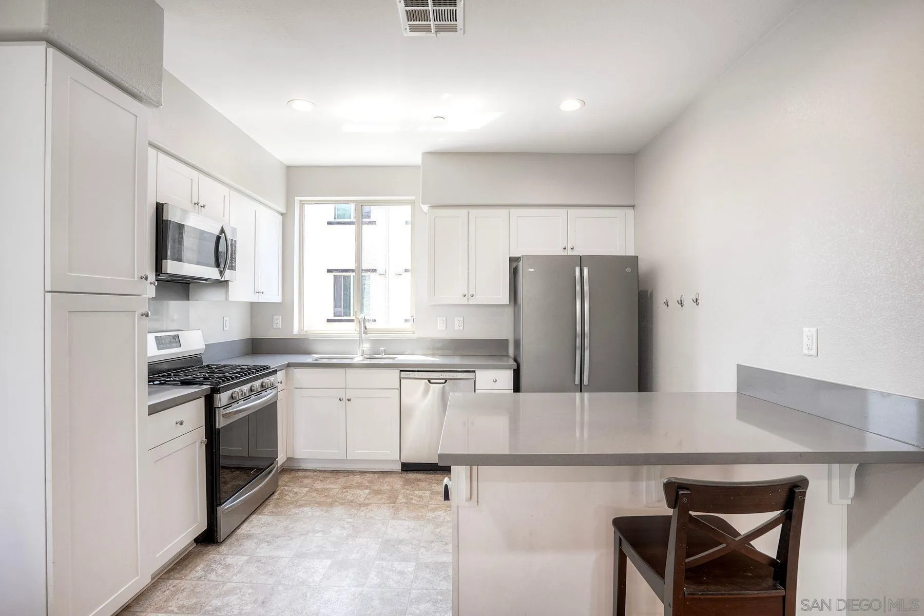 8850 Olive Lane, Unit 7 Santee, CA 92071 - Photo 6 of 27 a kitchen with granite countertop a refrigerator stove top oven and sink