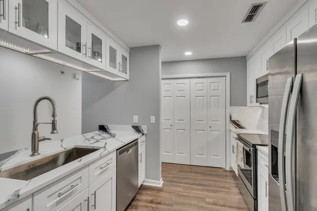 a kitchen with stainless steel appliances granite countertop a refrigerator and a sink