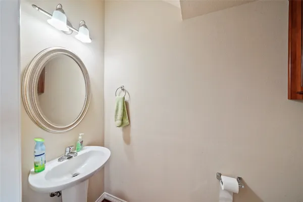 a bathroom with a sink mirror and a toilet