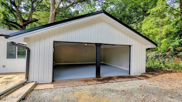 a view of backyard with a barn and a large tree