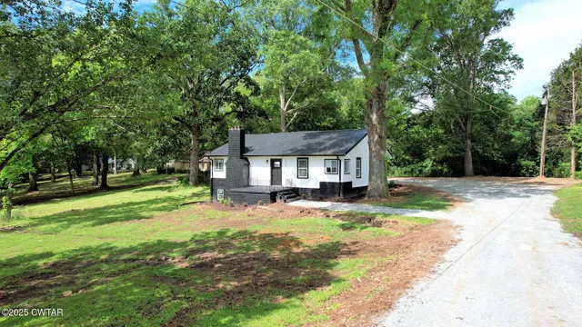 a view of a house with yard and tree s