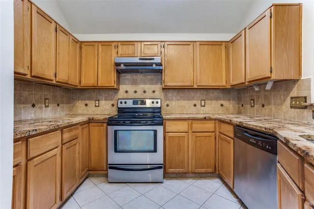 a kitchen with stainless steel appliances granite countertop a stove sink and cabinets