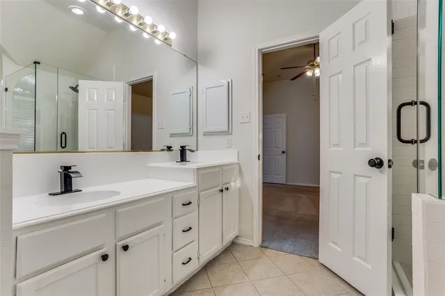 a bathroom with a double vanity sink mirror and shower