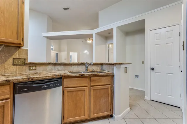 a kitchen with stainless steel appliances granite countertop a sink and cabinets with wooden floor