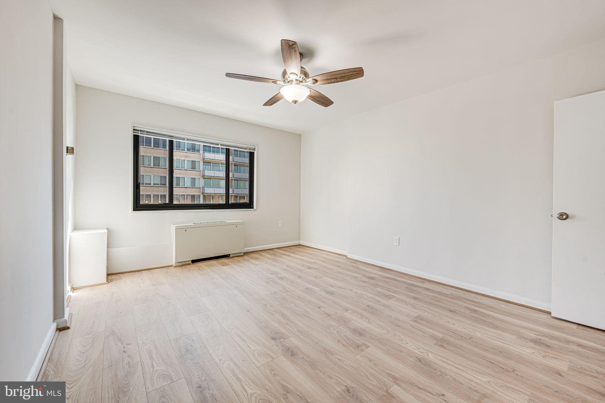 1200 South Arlington Ridge Road, Unit 714 Arlington, VA 22202 - Photo 14 of 24 an empty room with wooden floor chandelier fan and windows