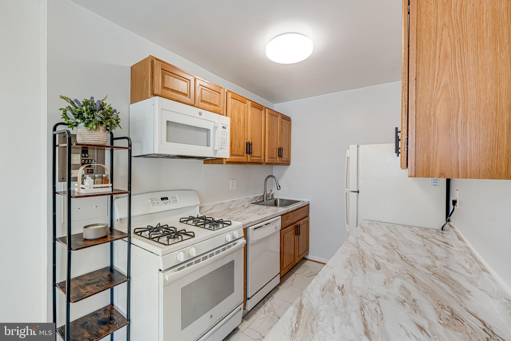 1200 South Arlington Ridge Road, Unit 714 Arlington, VA 22202 - Photo 10 of 24 a kitchen with a stove and a microwave