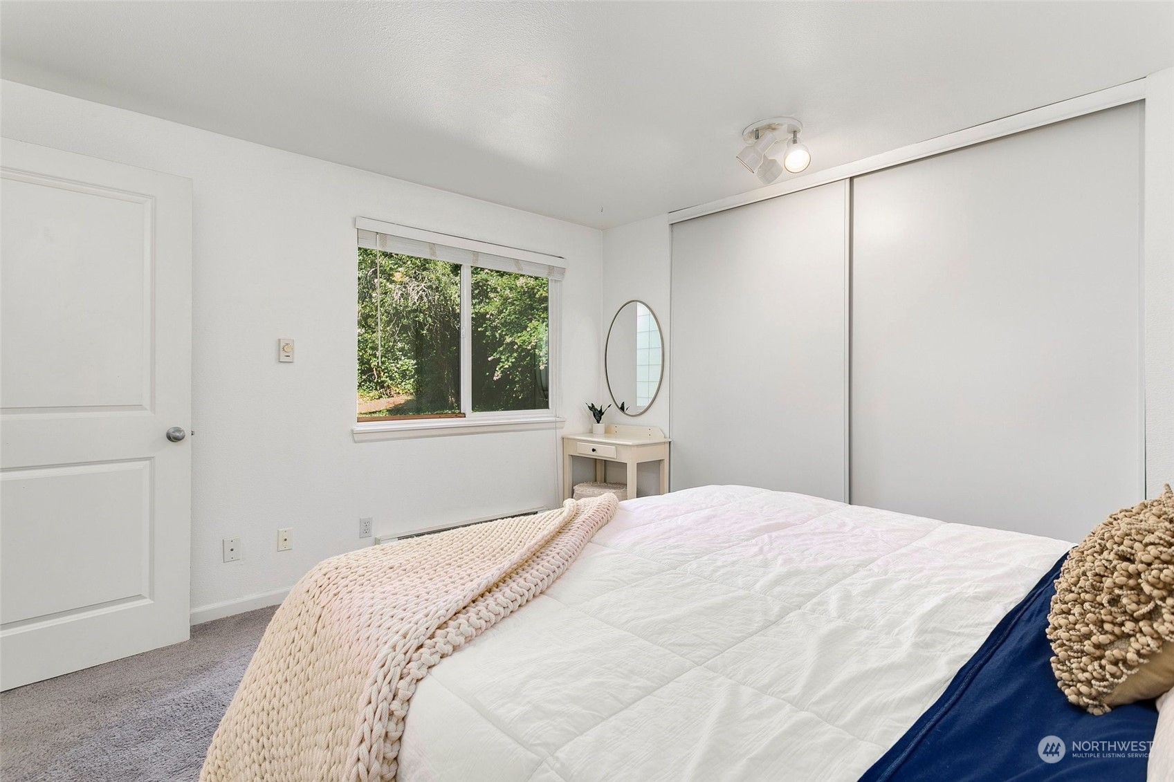 10822 Northeast 148th Lane, Unit J101 Bothell, WA 98011 - Photo 11 of 22 a bedroom with a bed a chandelier and a window