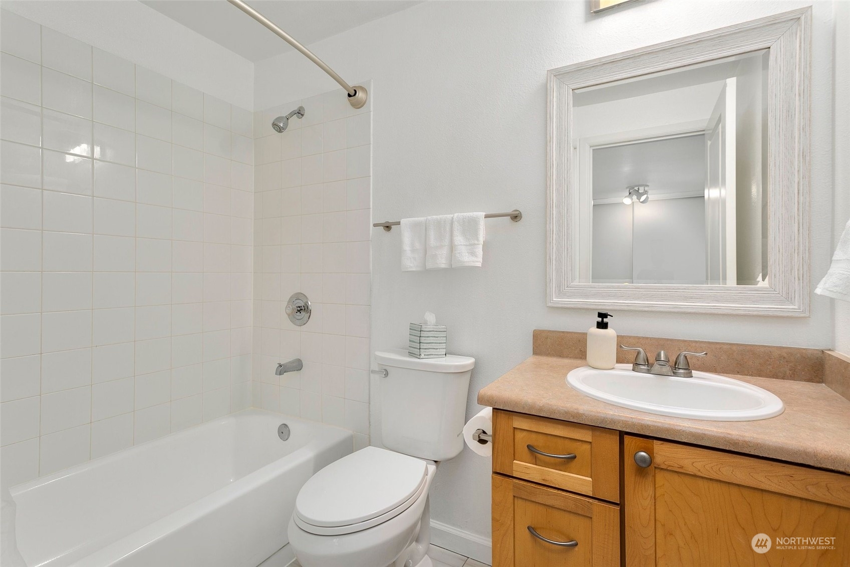 10822 Northeast 148th Lane, Unit J101 Bothell, WA 98011 - Photo 12 of 22 a bathroom with a sink toilet vanity tub and shower
