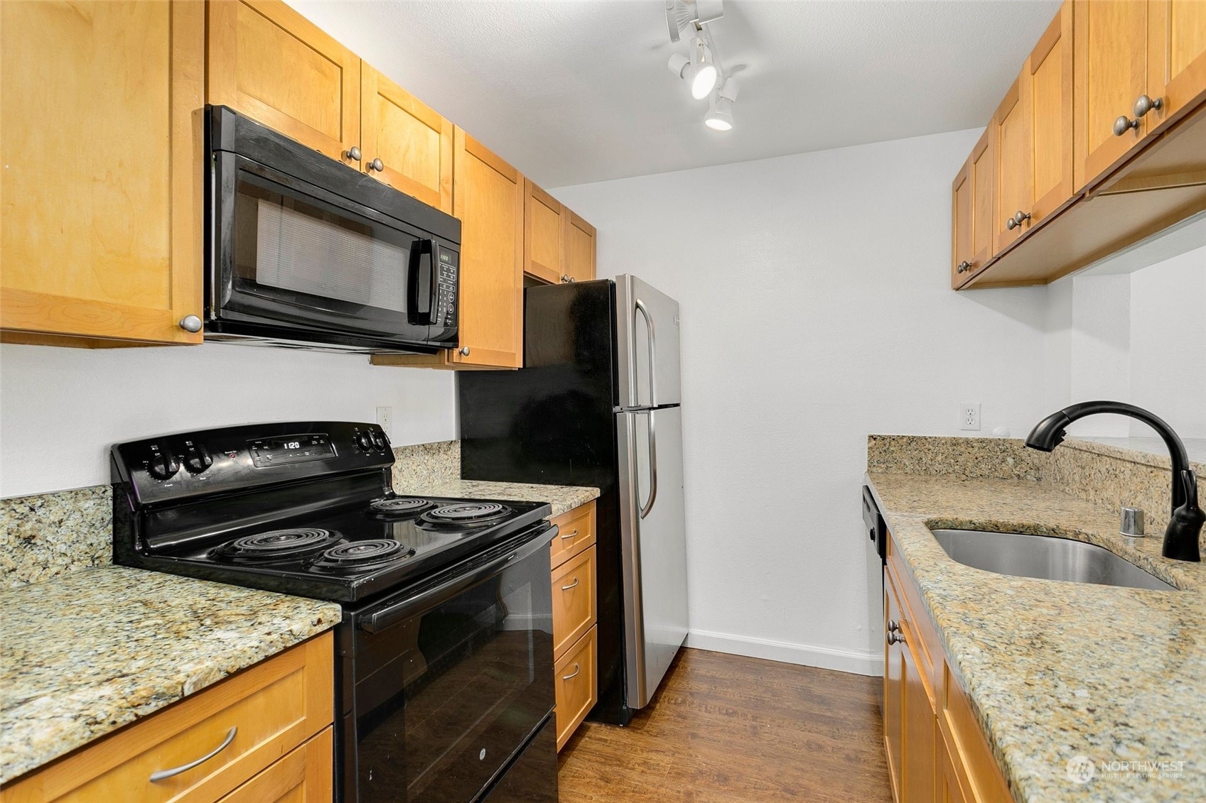 10822 Northeast 148th Lane, Unit J101 Bothell, WA 98011 - Photo 9 of 22 a kitchen with stainless steel appliances granite countertop a stove microwave and sink