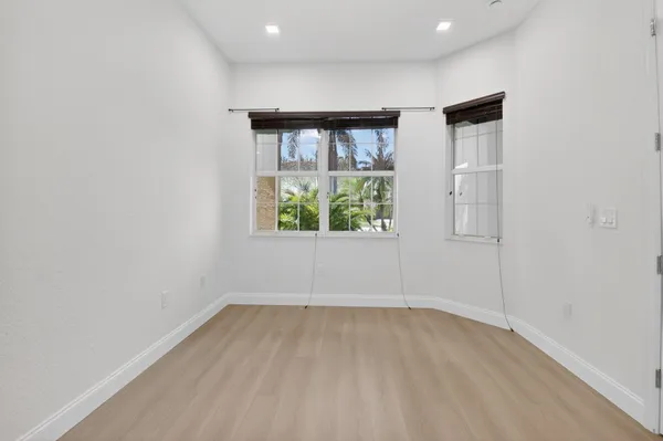 a dining room with wooden floor and furniture