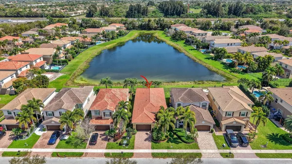 front view of house with a yard and palm trees