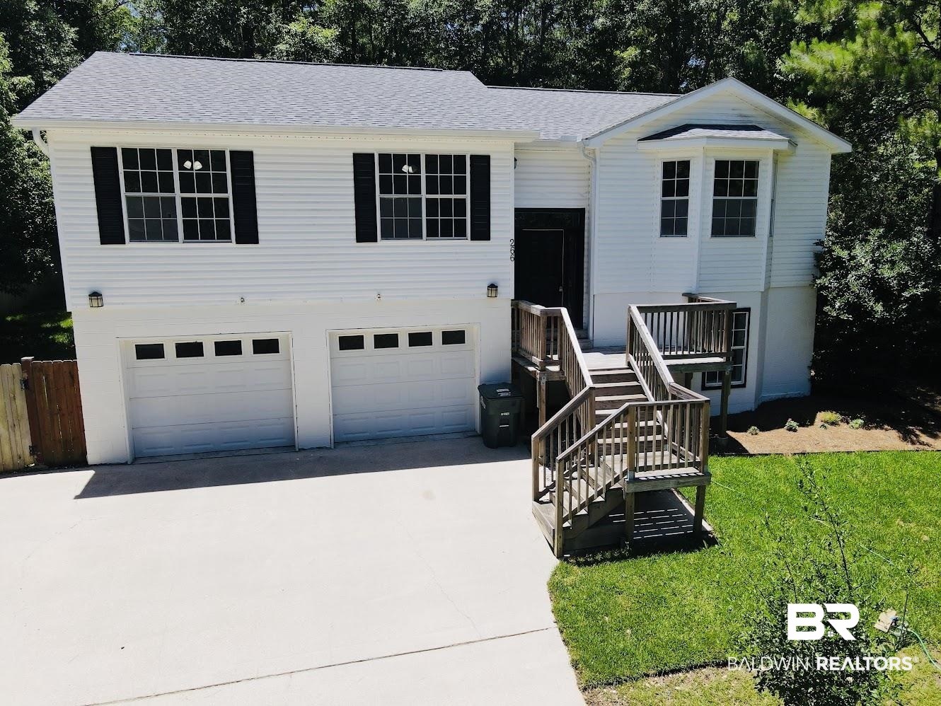 266 Ridgewood Drive Daphne, AL 36526 - Photo 2 of 34 Split-level residence featuring white siding, a two-car garage, and a wood deck entry