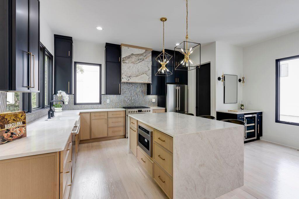 3960 Clairmont Road Chamblee, GA 30341 - Photo 8 of 63 a large kitchen with stainless steel appliances a large counter top a stove a chimney a sink and a refrigerator