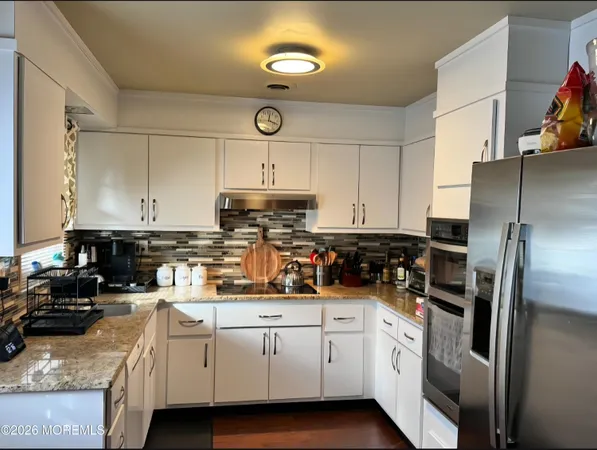a kitchen with cabinets stainless steel appliances and a sink