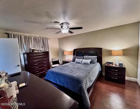 a bedroom with bed and wooden floor