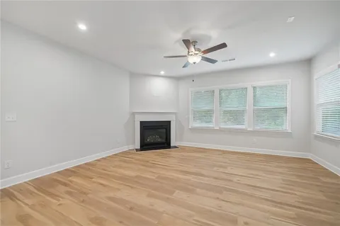 a view of an empty room with a window and a kitchen