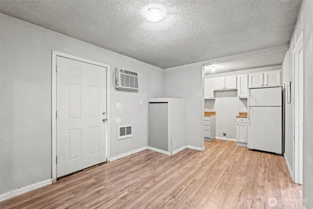 a view of a kitchen with wooden floor and refrigerator in kitchen