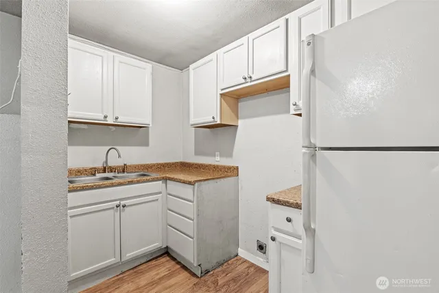 a kitchen with white cabinets and white appliances