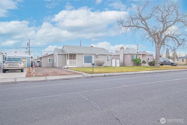 a view of pool with large trees and cars parked in front of it