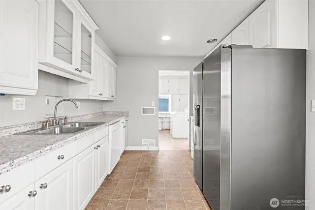 a kitchen with stainless steel appliances granite countertop a refrigerator and a sink