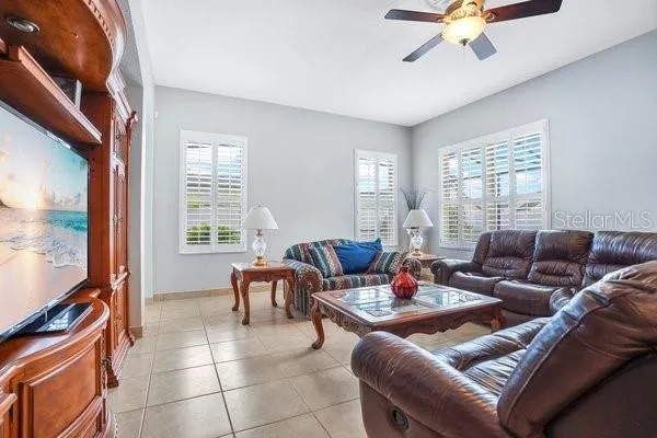 a living room with furniture a flat screen tv and a window