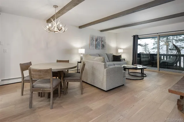 a living room with furniture chandelier and a large window