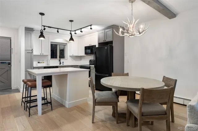a kitchen with stainless steel appliances a table chairs and chandelier